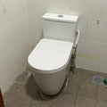 White toilet in a bathroom with tiled walls and floor.